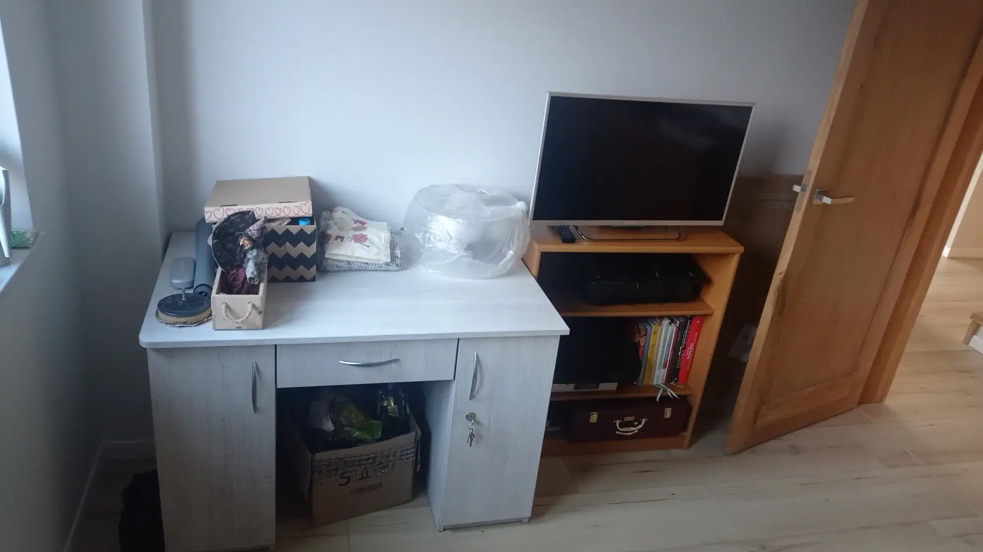 Dodatkowy pokój przed metamorfozą: biurko i telewizor na szafce