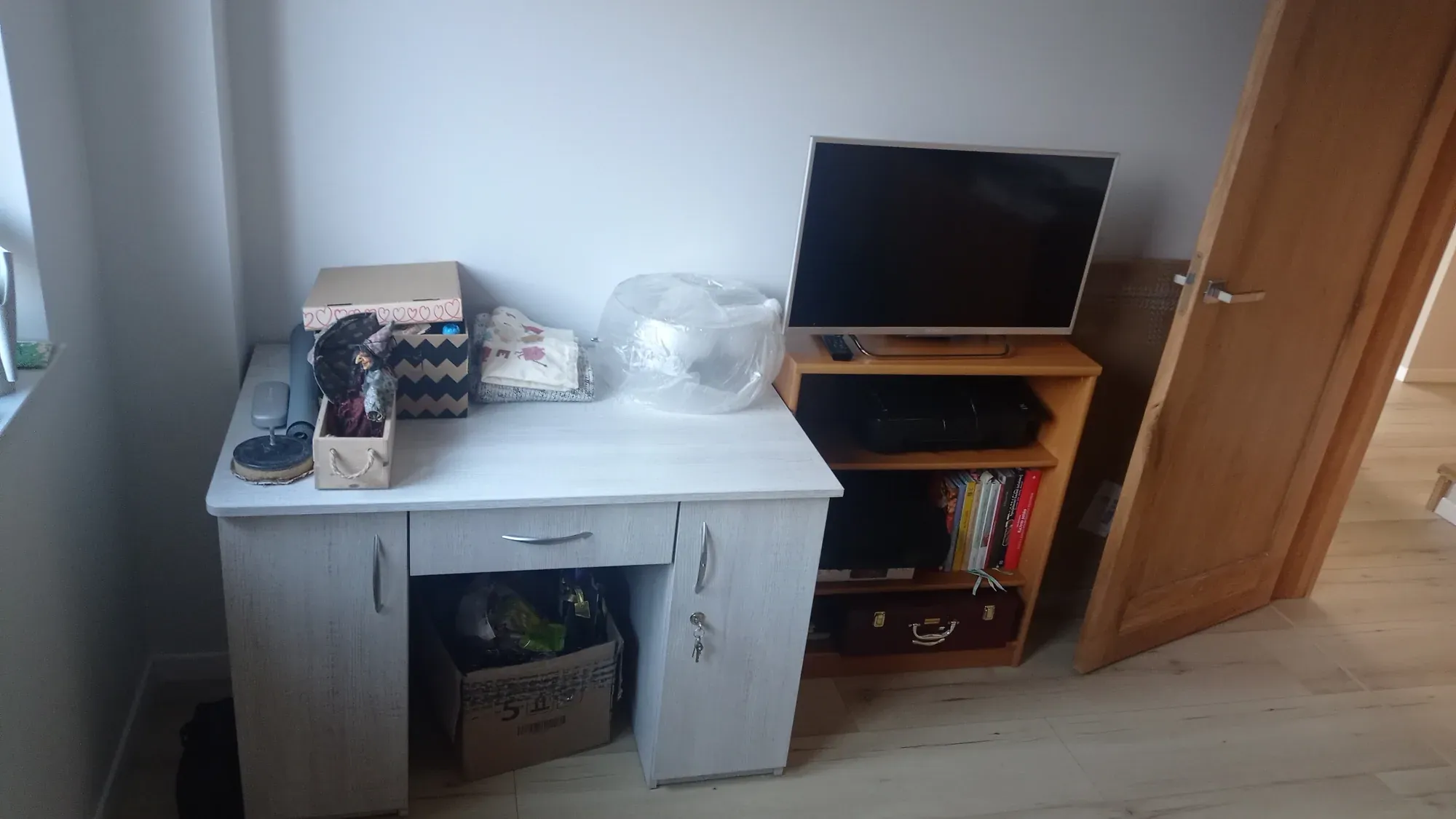Dodatkowy pokój przed metamorfozą: biurko i telewizor na szafce