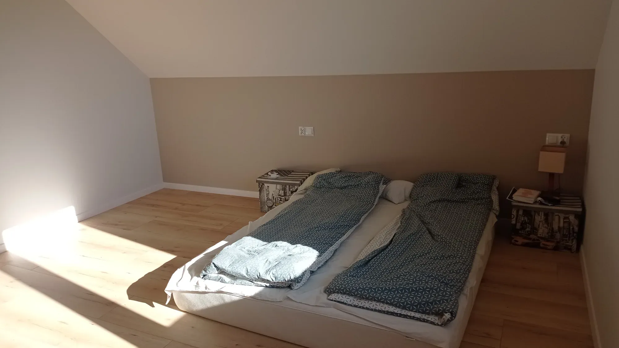 Sypialnia przed metamorfozą: dwa materace na podłodze pod skosem