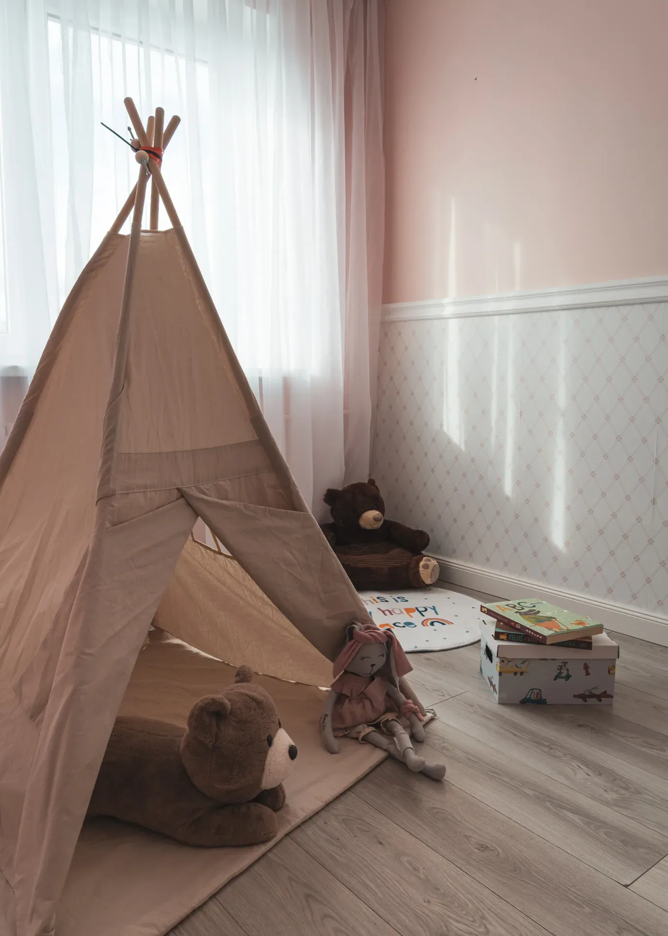 Tipi i pluszowe zabawki w różowym pokoju dziecka, widok od strony okna